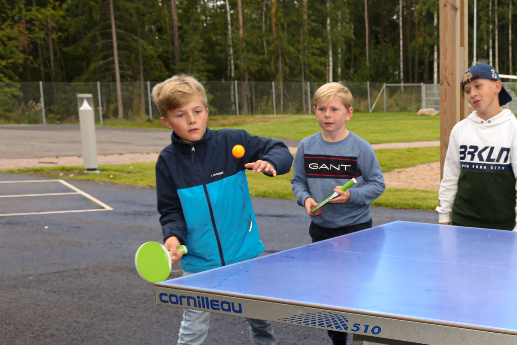 Elever som spelar pingis på skolgården