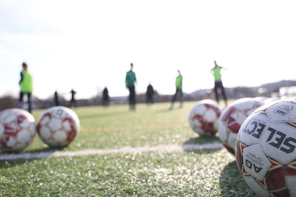 Fotbollsplan med fotbollar i förgrunden