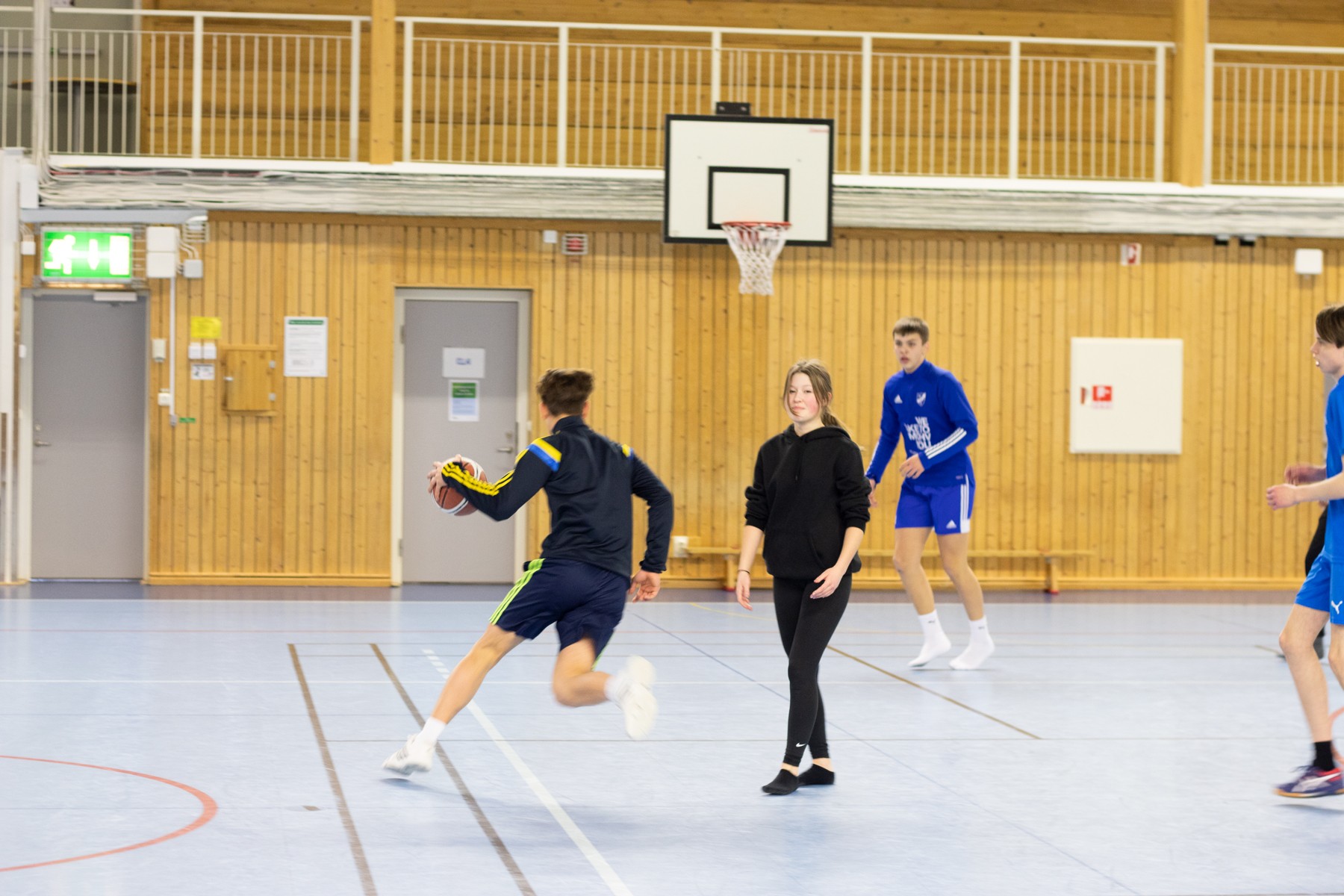 Elever spelar basket i gymnatiksal