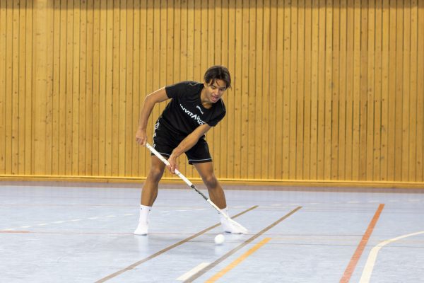 Elev spelar innebandy i gymnastiksal